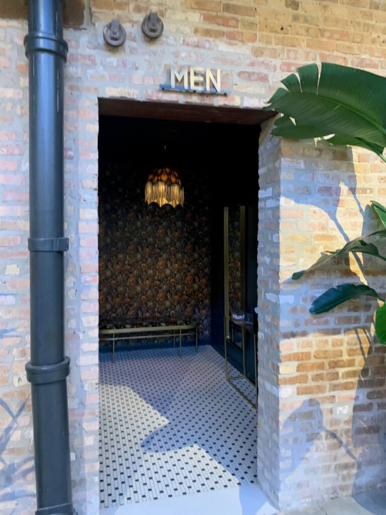 Brick wall with "Men" Sign